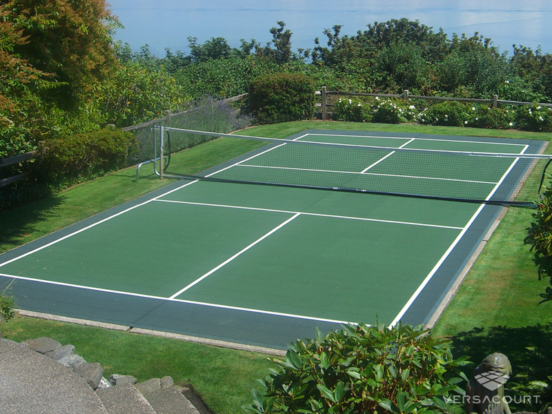 A VersaCourt pickleball court kit laid on a concrete pad