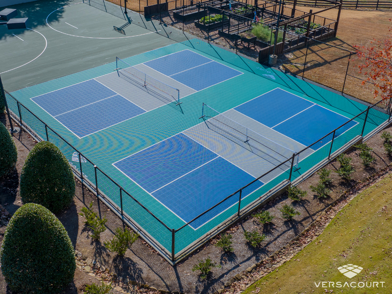 Players on a blue and green VersaCourt pickleball court in a garden